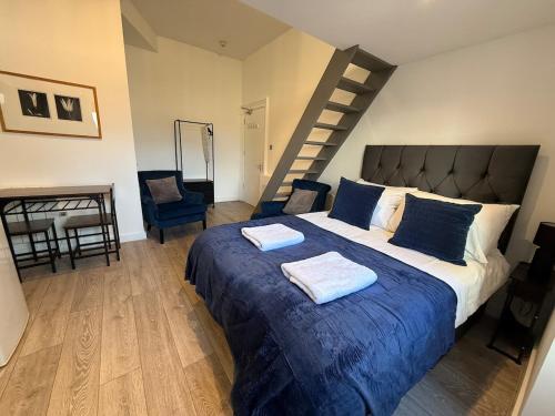 Un dormitorio con una cama grande y una escalera. en Carmen Sylva Llandudno G Floor Studio 2, en Llandudno