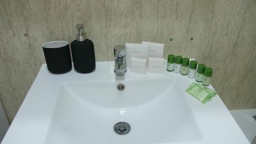a white bathroom sink with bottles and a faucet at Stylish 4 Bd Ft LDN Parking in London