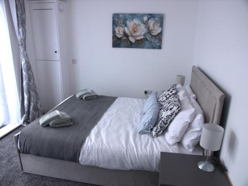a bed in a bedroom with a picture on the wall at Stylish 4 Bd Ft LDN Parking in London
