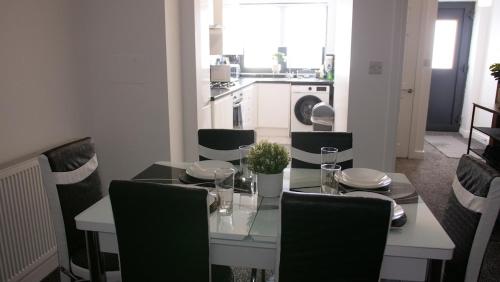 a dining room with a table and chairs and a kitchen at Stylish 4 Bd Ft LDN Parking in London