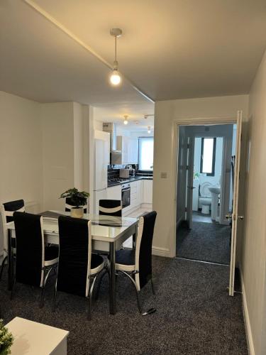 a kitchen and dining room with a table and chairs at Stylish 4 Bd Ft LDN Parking in London