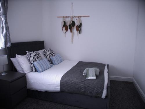 a bedroom with a large bed with blue pillows at Stylish 4 Bd Ft LDN Parking in London