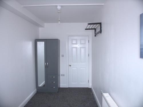 an empty hallway with a door and a mirror at Stylish 4 Bd Ft LDN Parking in London
