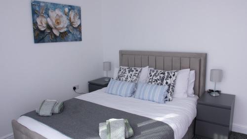 a bedroom with a bed with two night stands and two lamps at Stylish 4 Bd Ft LDN Parking in London