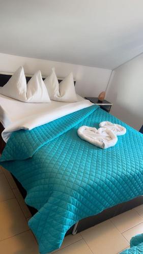 a bed with a green comforter and two towels on it at Charter Apartments Costea in Sibiu