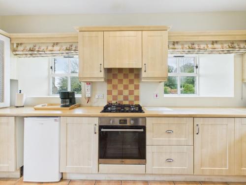 a kitchen with white cabinets and a stove top oven at Tollymore Forest family house Mourne Mountains in Bryansford