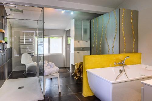 a bathroom with a sink and a yellow wall at Palais Aoma, hôtel particulier de luxe en Provence in LʼIsle-sur-la-Sorgue