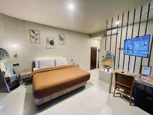 ParagajenにあるHeHa Waterfall Suites & Camping Groundのベッドと薄型テレビのある寝室
