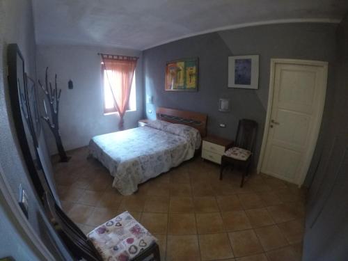 a bedroom with a bed and a window and a door at La casa di Pluto in Farigliano