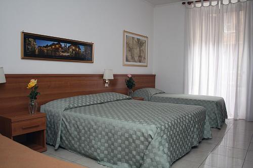 una camera con due letti con trapunte verdi di Emanuela B&B a Roma