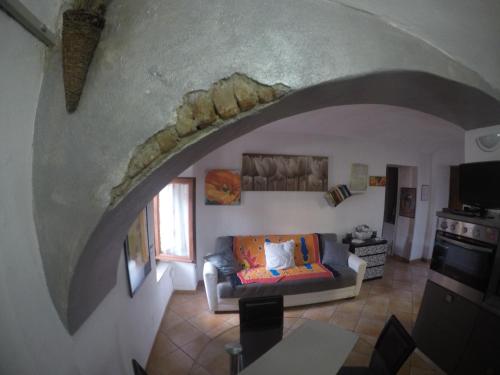 a living room with a couch and an archway at La casa di Pluto in Farigliano