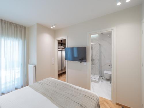a bedroom with a bed and a television on the wall at The Samirah Luxury Residences in Elliniko in Athens