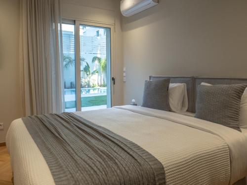 a bedroom with a large bed with a large window at The Samirah Luxury Residences in Elliniko in Athens