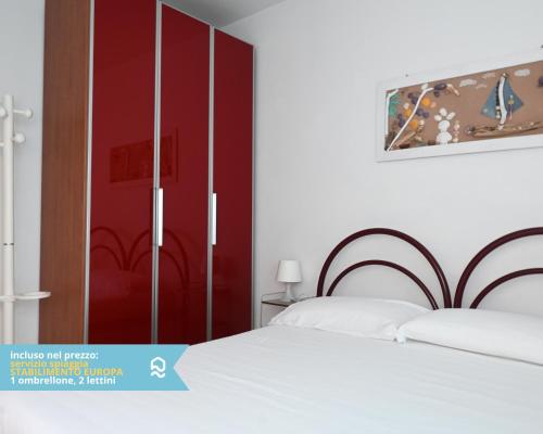 a bedroom with two beds and a red closet at RS314 - Marcelli, bilocale in residence fronte mare in Marcelli