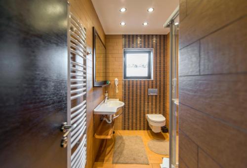 a small bathroom with a toilet and a sink at Guest House Panorama Aqualux with Free Parking in Novi Sad