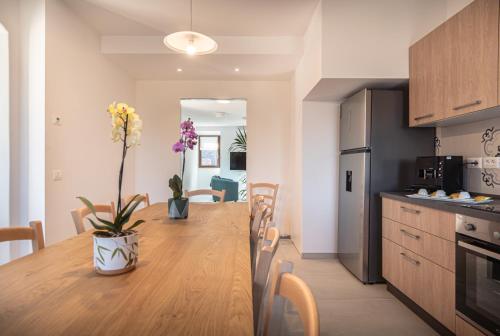 a kitchen and dining room with a wooden table with flowers at Le Dimore della Custodia in Assisi