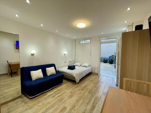 une chambre avec un lit et un canapé bleu dans l'établissement Studio Mozart Passy Paris, à Paris