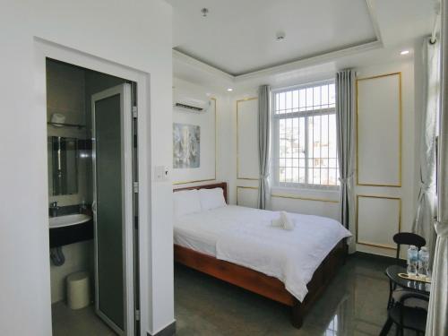 a bedroom with a bed and a sink and a window at Ngọc Châu Hotel in Vung Tau