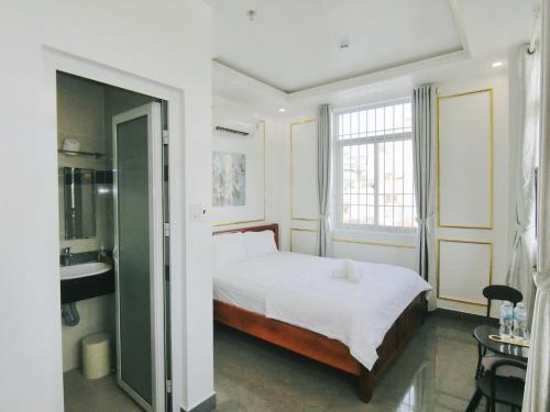 a bedroom with a bed and a bathroom with a sink at Ngọc Châu Hotel in Vung Tau