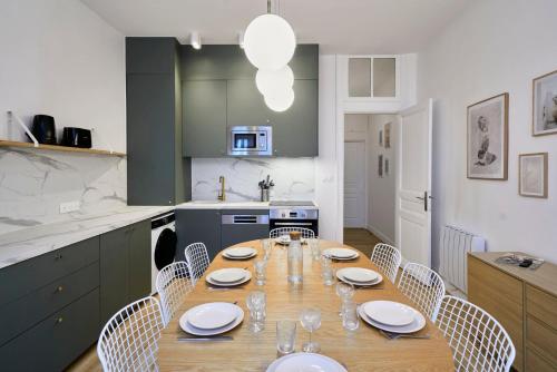 une cuisine avec une table en bois et des chaises ainsi qu'une salle à manger dans l'établissement Maison 5 chambres & 5 sdb proche métro & commerces, à Lille