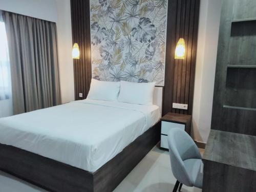 a hotel room with a bed and a chair at Apartement Lucky Jimbaran in Jimbaran