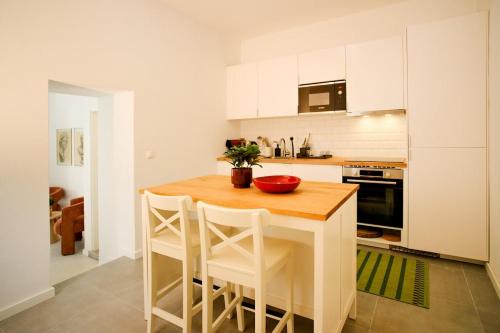 a kitchen with a wooden table and white cabinets at Casa da Serra - Entire 3 Bedroom House with Pool and Fireplace in Monchique
