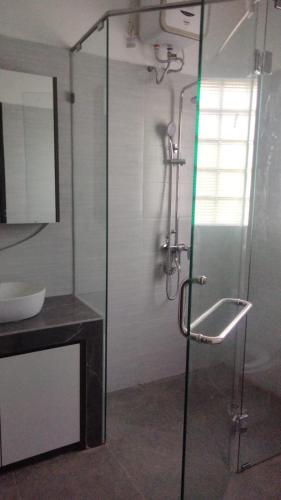 a bathroom with a glass shower with a sink at Apartement Lucky Jimbaran in Jimbaran