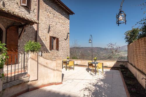 a patio with a table and chairs and a building at Le Dimore della Custodia in Assisi