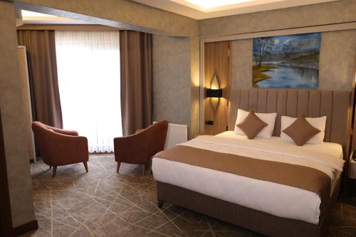 a hotel room with a bed and two chairs at Mir Emir Hotel in Bostaniçi