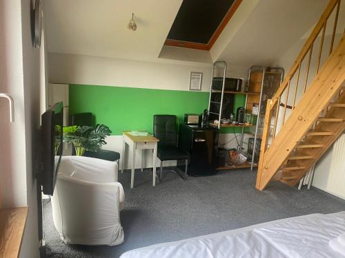 a room with a bed and a green wall at SECRA Exclusive Maisonette-Ferienzimmer Am Backhausgarten in Flonheim