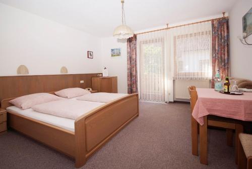 a bedroom with a bed and a table and a table and a table at Pension Schwaiger in Bad Gögging