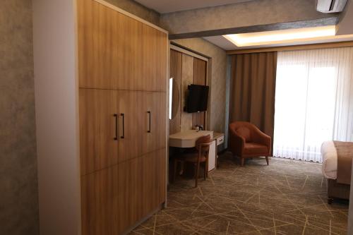 a hotel room with a bed and a desk and a cabinet at Mir Emir Hotel in Bostaniçi