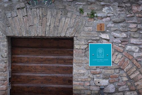 a wooden garage door in a stone wall with a sign at Le Dimore della Custodia in Assisi