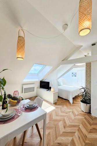 - un salon blanc avec un lit et une table dans l'établissement L'Eden - calme et luminosité au coeur de la ville, à Fougères