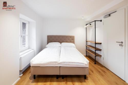 a white bedroom with a bed and a closet at Altstadt Apartments in Schongau