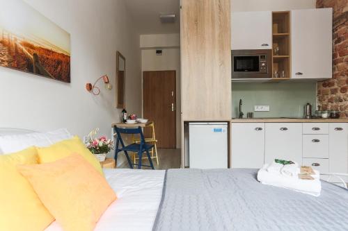 a bedroom with a white bed and a kitchen at Simply Modern Apartments in Toruń
