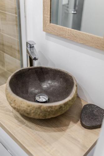 a bathroom sink sitting on top of a wooden counter at Simply Modern Apartments in Toruń