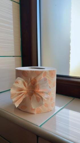 a roll of toilet paper with a flower on a table at Charter Apartments Costea in Sibiu
