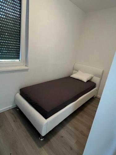 a bed in a room next to a window at Apartma Korte in Izola