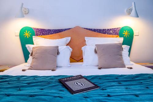 a book sitting on top of a bed at Palais Aoma, hôtel particulier de luxe en Provence in LʼIsle-sur-la-Sorgue