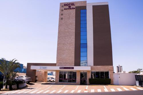 a building with a clock tower in a parking lot at Hotel Euro Suite São Jose do Rio Preto by Nacional Inn in Sao Jose do Rio Preto