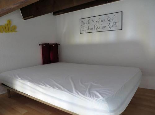 - un lit blanc dans une chambre avec un panneau mural dans l'établissement Appartement saisonnier à la semaine, au Cap d'Agde