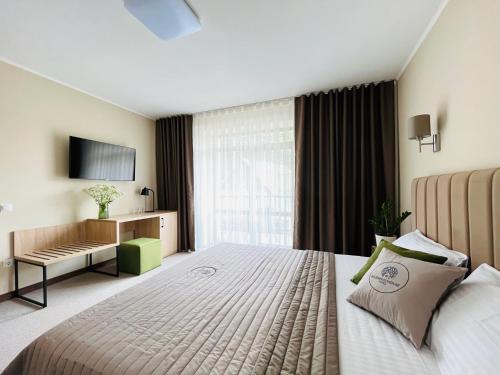 a hotel room with a large bed and a television at Blueberryhouse in Bukovel