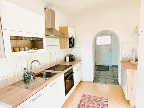 a kitchen with white cabinets and a sink at Grafs Landhaus im Südburgenland in Oberdorf im Burgenland