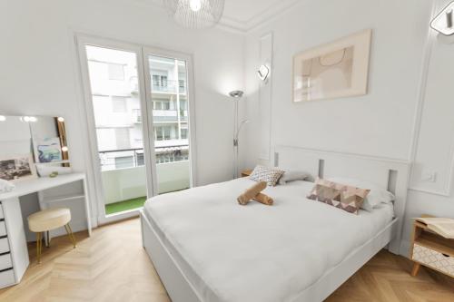 - une chambre blanche dotée d'un lit avec une poupée dans l'établissement Le Versailles - Hypercentre - Luxurious - Spacious - AC, à Antibes