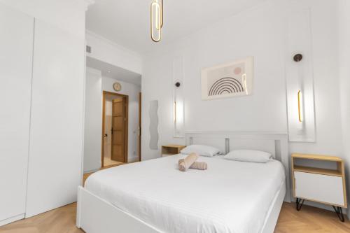 une chambre blanche avec un lit blanc et une télévision dans l'établissement Le Versailles - Hypercentre - Luxurious - Spacious - AC, à Antibes