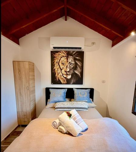 a bedroom with a bed with a lion painting on the wall at בקתה 21 in Yuval