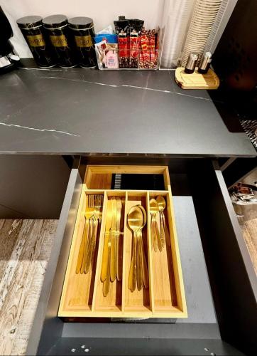 a drawer filled with gold spoons on a shelf at בקתה 21 in Yuval