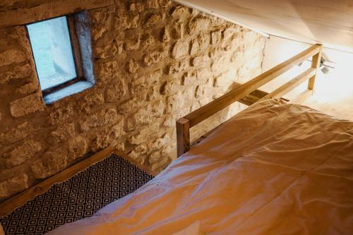 a bedroom with a bed in a stone wall at Vakantiewoning BienViennue in Marcilly-sur-Vienne
