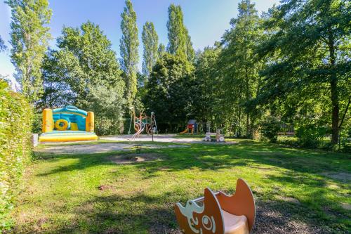 un parc avec une aire de jeux sur gazon dans l'établissement Camping Paradis Le Giessen, à Bassemberg